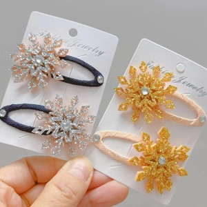 Dettaglio di fermagli per capelli a fiocco di neve glitterati con strass su cartoncino
