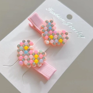 Detail of sweet heart-shaped hair clips with colorful candy beads and sparkling rhinestones