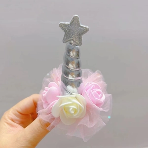 Detailed view of unicorn hair clip with silver star, rose flowers and pink lace mesh