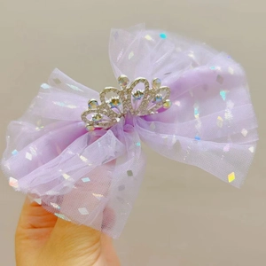 Dettaglio molletta a fiocco in tulle viola con corona d'argento e paillettes per bambine