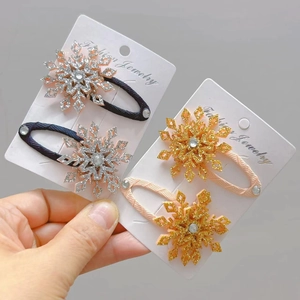 Dettaglio di fermagli per capelli a fiocco di neve glitterati con strass rosa e blu