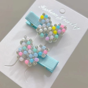 Detail of butterfly hair clips with colorful pearls and rhinestones on blue ribbons