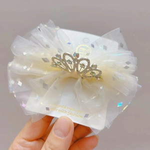 Dettaglio del cerchietto con fiocco in tulle glitterato e corona d'argento con strass