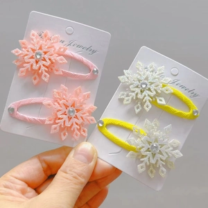 Dettaglio di fermagli per capelli a fiocco di neve glitterati con strass su carte
