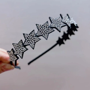 Detailed view of the sparkling rhinestone star elements on a non-slip fabric headband