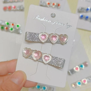 Set of two sparkly pink heart gemstone hair clips on a silver glitter base for women