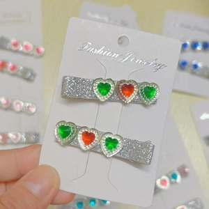 Detail of silver glitter hair clips with three faceted heart-shaped resin gemstones