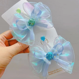 Detailed macro of blue iridescent organza bow hair clips with heart accents for girls