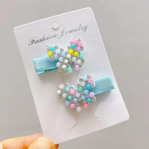 Detail of two-piece butterfly hair clips with colorful faux pearls and sparkling crystals