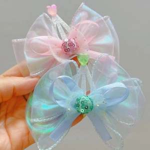 Close-up of translucent organza butterfly hair clips with shimmering heart beads and silver trim