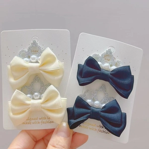 Vue détaillée de barrettes à nœuds avec couronne et perles pour petites filles