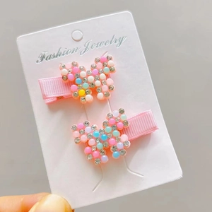 Detail of butterfly hair clips with colorful beads and rhinestones on card