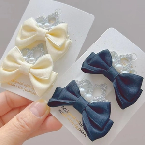 Détail de barrettes en soie avec couronnes argentées et perles pour coiffures de filles