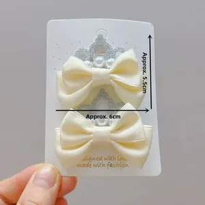 Détail de nœuds barrettes crème avec couronne pailletée et perles, taille 6cm pour filles