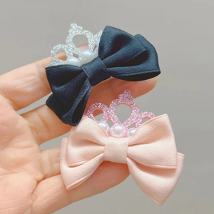 Détail de barrettes couronne à paillettes avec perles sur nœuds roses et noirs