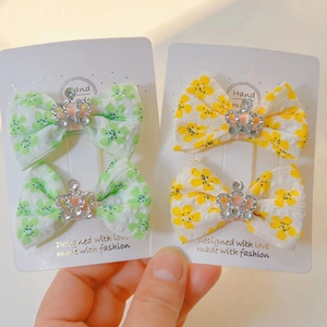 Détail de nœuds à cheveux en tissu floral avec accents de couronnes en strass