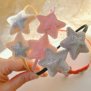 Dettaglio ravvicinato di cerchietti con stelle di paillettes con consistenza vellutata