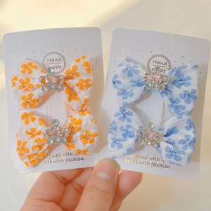 Gros plan de barrettes à nœuds fleuris avec couronnes en strass, bleu et orange