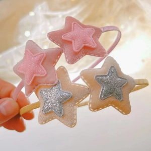 Dettagli di cerchietti in velluto rosa e beige con stelle glitterate per bambine