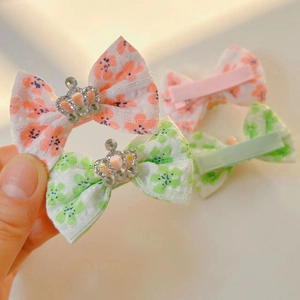 Détail de barrettes à nœuds floraux avec couronnes étincelantes et pinces en tissu