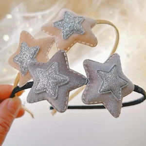 Dettaglio dei cerchietti con stelle di paillettes e morbido tessuto in champagne e grigio