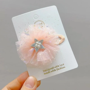 Dettaglio di fermaglio per capelli a fiore in rete rosa con stella di paillettes blu