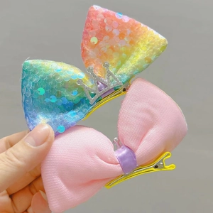 Detail von rosa Stoffschleife und glitzernder Paillettenschleife mit Silberkrone