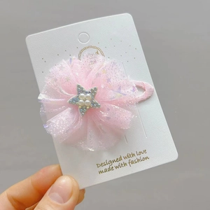 Fermaglio per capelli a fiore in tulle rosa con stella di perle su carta