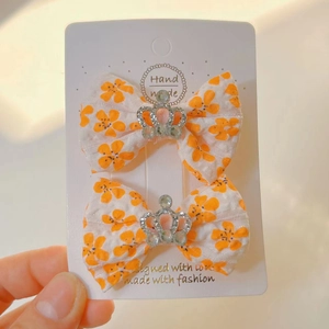 Détail de pinces à cheveux nśud fleuri avec couronne en argent et strass