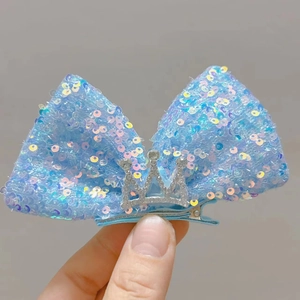 Nahaufnahme der blauen Glitzer-Schleifen-Haarspange mit silberner Strass-Krone