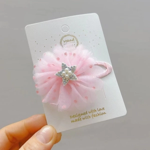 Dettaglio di fermaglio a fiori in rete rosa con stella glitterata e perle per bambine