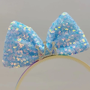 Detail van de lichtblauwe pailletten strik hoofdband met zilveren kristallen kroon
