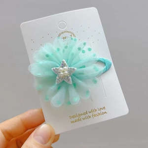 Dettaglio del fermaglio per capelli a fiore in tulle verde menta con stella di perle