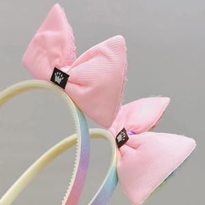 Detail van haarband met roze pailletten strik, kroonlabel en antislip tanden voor meisjes
