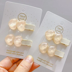 Dettaglio mollette per capelli a cuore traslucido con rivestimento in nastro bianco