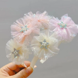 Dettaglio dei cerchietti con fiori in tulle rosa e giallo con stelle di perle per bimbe