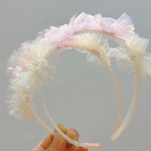 Dettaglio dei cerchietti in rete plissettata rosa e beige con pettini interni antiscivolo