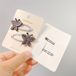 Detail of glitter butterfly hair clips with colorful sequins and silver fabric wrapping