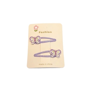 Détail de deux barrettes papillon violettes avec paillettes sur carte support