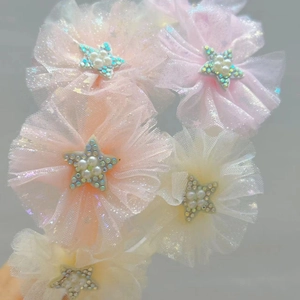 Dettaglio accessori per capelli a fiori in rete con perle e decorazione a stella lucida