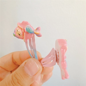 Dettaglio di fermagli per capelli in resina rosa a forma di pesce con clip BB sfumate