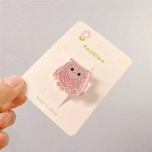 Sparkling pink owl hair clip with silver rhinestones on a fashion display card