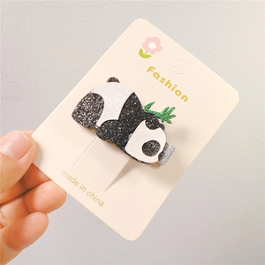 Sparkly glitter panda hair clip with green leaf detail on a display card for girls