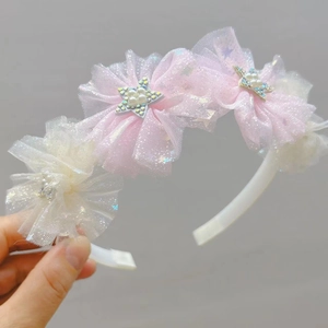 Dettaglio del cerchietto per bambini con fiori in tulle rosa e stelle scintillanti
