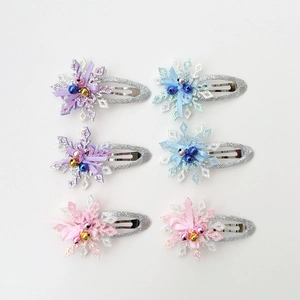 Set of 6 sparkly Christmas snowflake hair clips in purple, blue, and pink glitter finishes