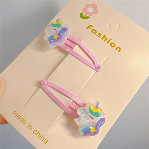 Dettaglio di fermagli BB rosa glitterati per bambine con decorazioni in acrilico unicorno