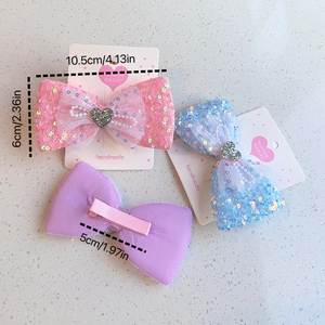 Vue détaillée du lot de 3 barrettes nœuds à paillettes avec strass cœur et perles