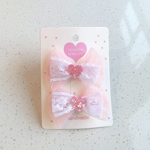Pink lace bow hair clips for girls with glittery heart detail on display card
