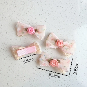 Detailed view of pink floral lace bow hair clips with satin roses and size measurements