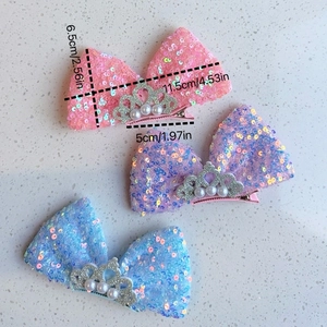 Détail des barrettes à cheveux avec nœuds pailletés, motif couronne et perles nacrées